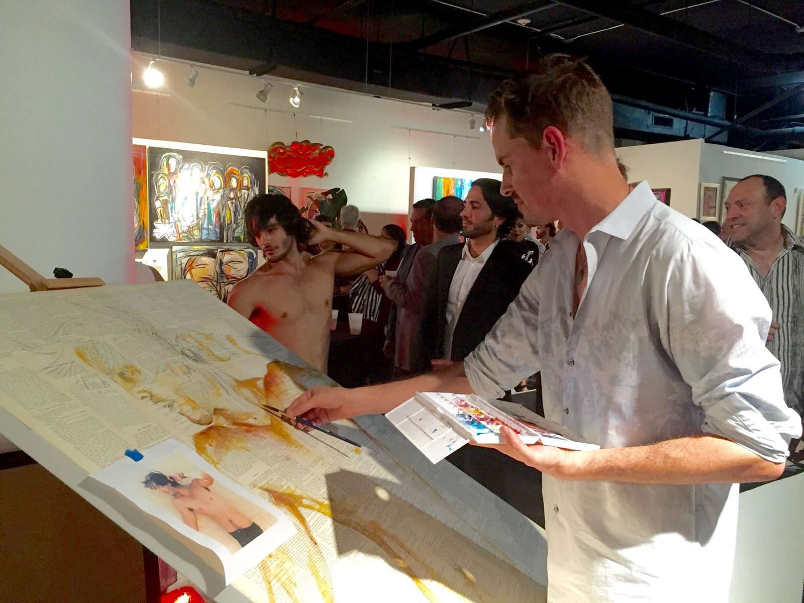 Brenden Sanborn painting a live watercolor on book pages with a model at Nina Torres Gallery during Art Basel Miami, 2015