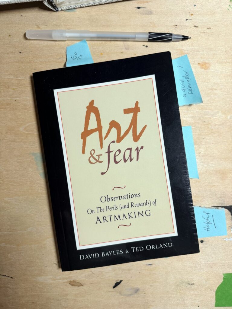 Brenden Sanborn's copy of Art and Fear by David Bayles and Ted Orland on his studio table, stuck full of sticky notes, with a pen