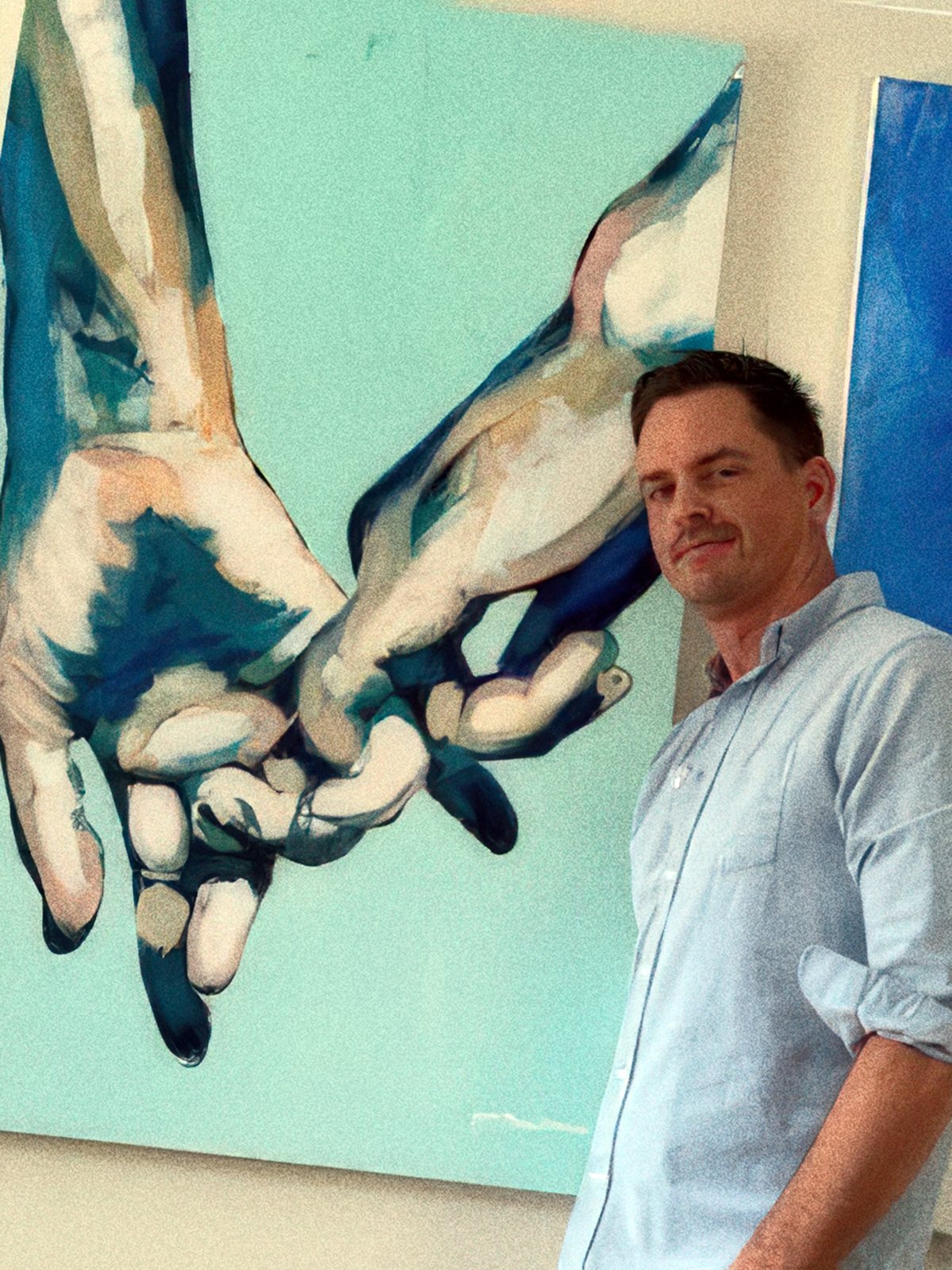 Brenden Sanborn standing beside his large painting of two hands holding