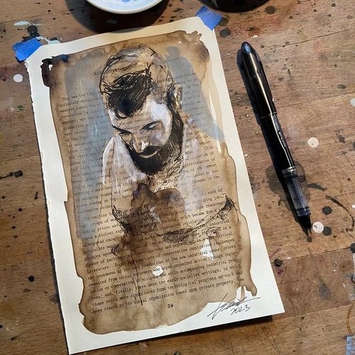 Custom ink portrait of a bearded man painted on a vintage book page by Brenden Sanborn, with his pen on the studio table