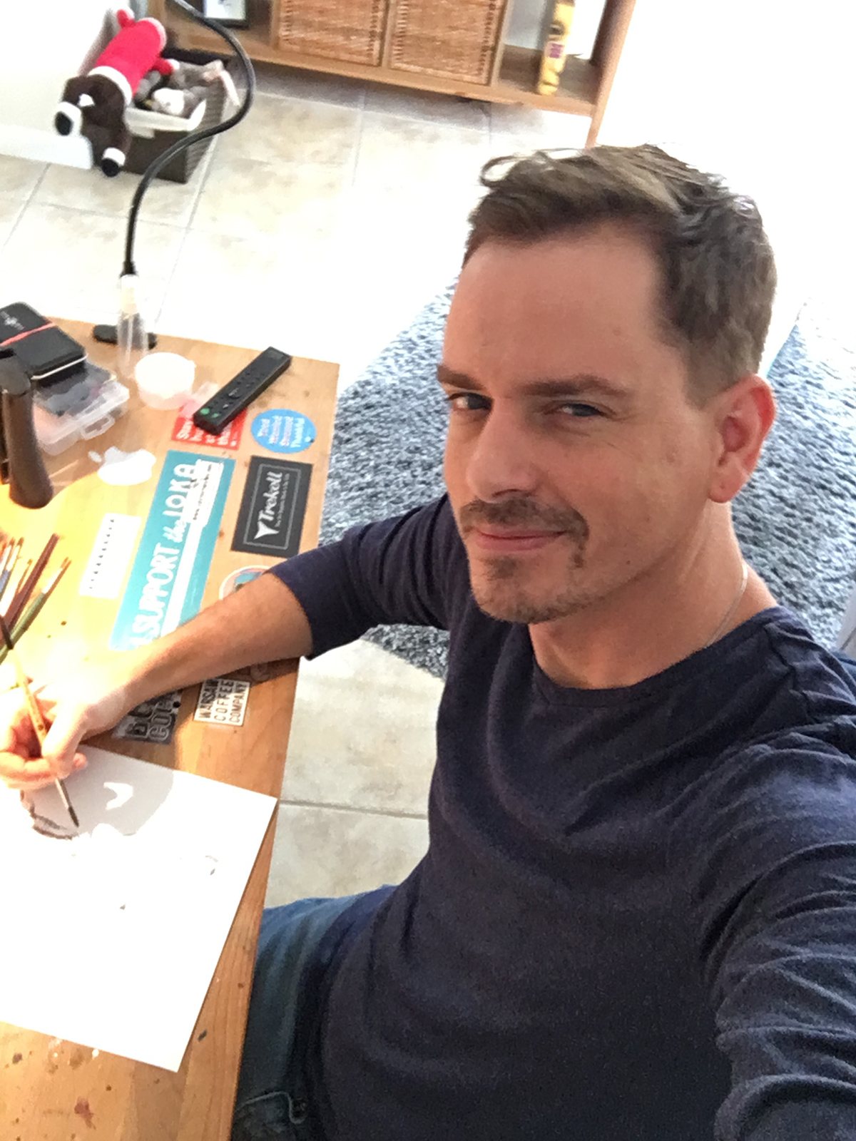 Brenden Sanborn painting a watercolor at his studio desk