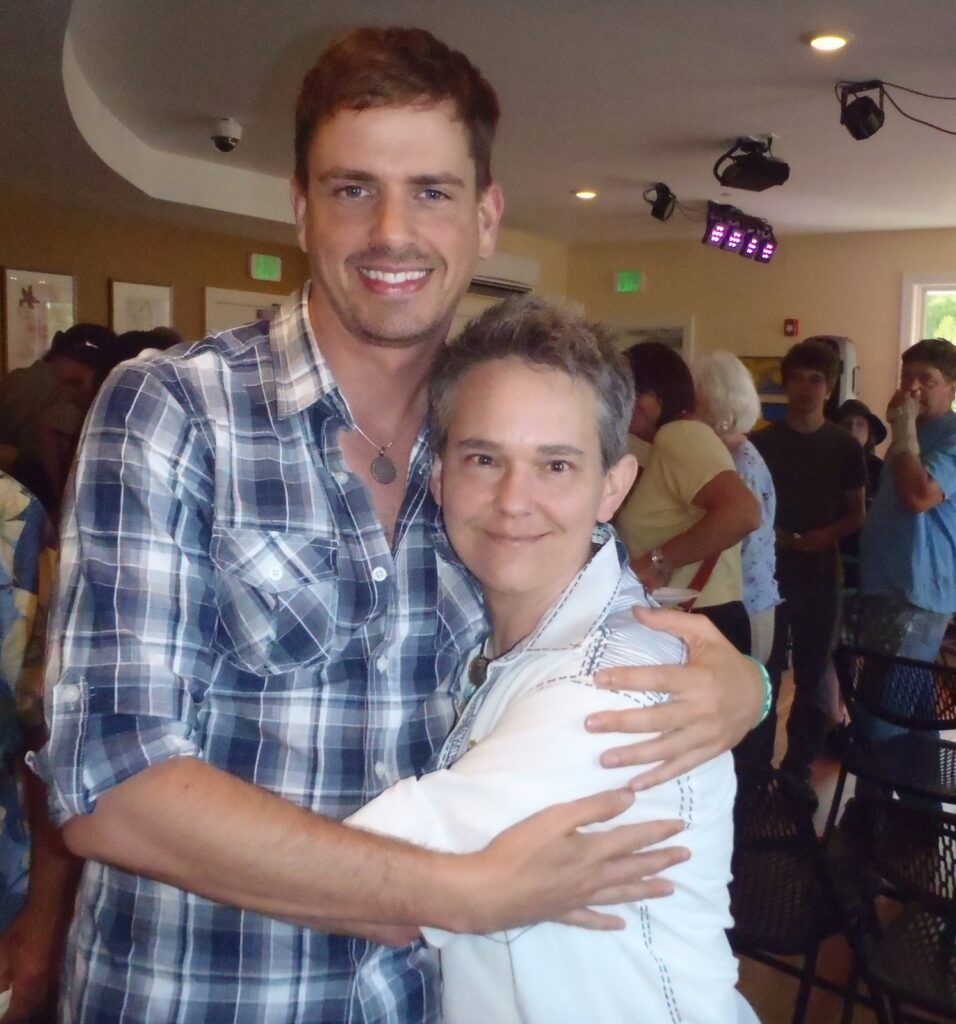 Brenden Sanborn hugging his friend Kelly Jo Shows at a busy art show in 2013